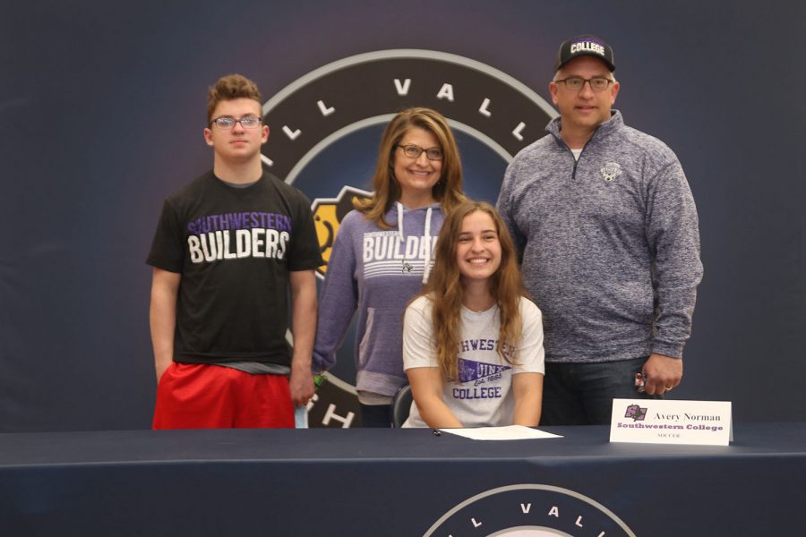 Senior Avery Norman signs and poses with her parents. Norman will attend Southwestern College for soccer.