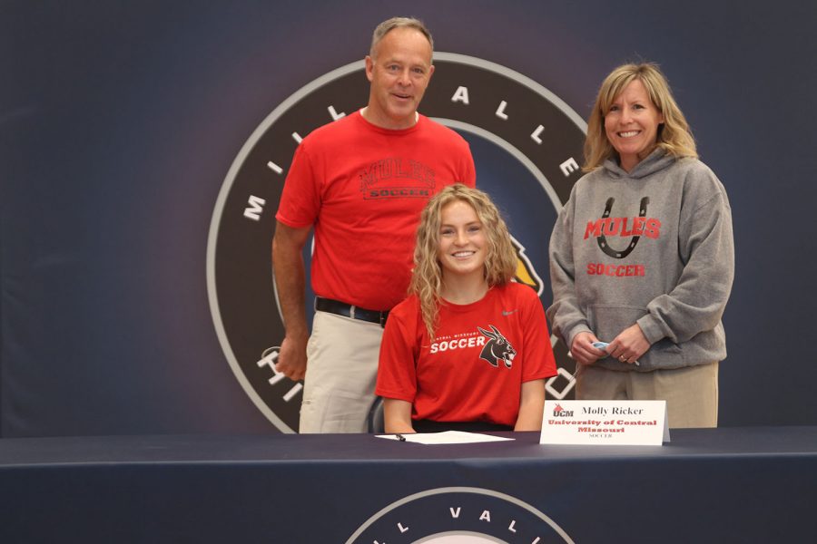 Senior Molly Ricker signs and poses with her parents. Ricker will attend University of Central Missouri for soccer.