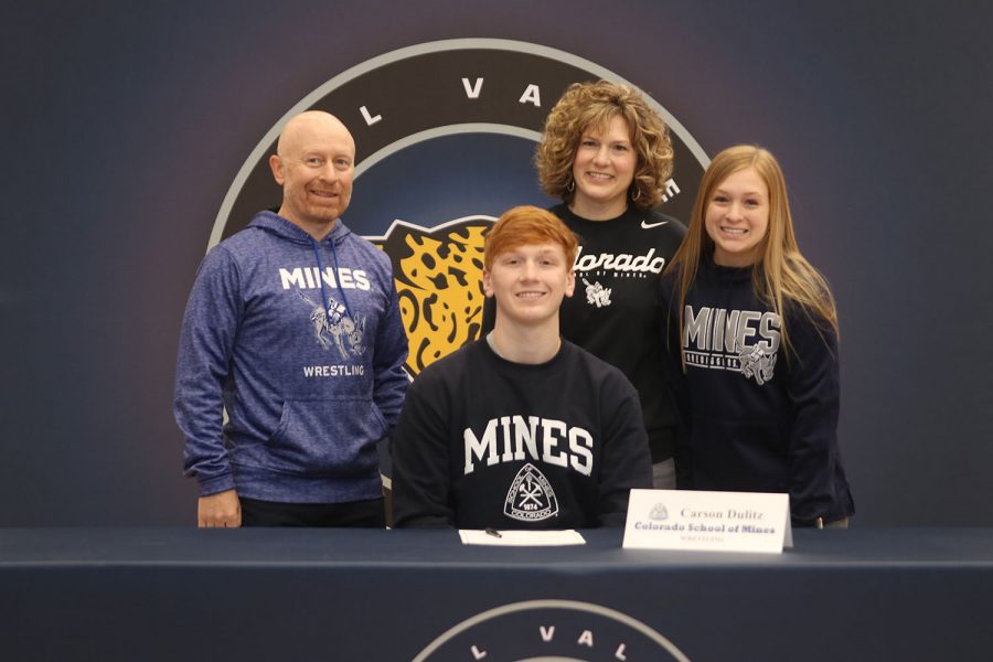 Senior Carson Dulitz signs and poses with his parents. Dulitz will attend Colorado School of Mines for wrestling.