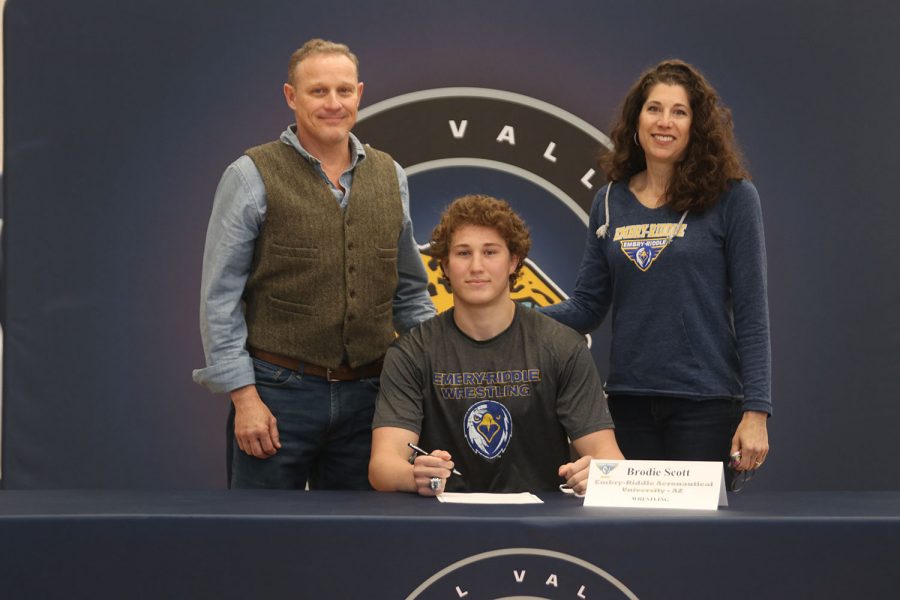 Senior Brodie Scott signs and poses with his parents. Scott will attend Embry-Riddle Aeronautical University for wrestling.