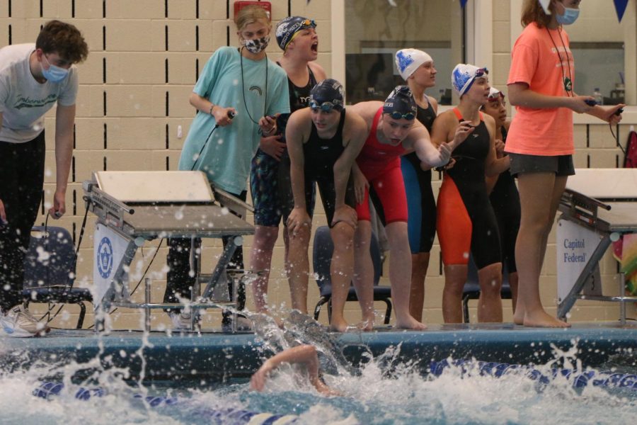 Focusing on the race, the 200-yard freestyle relay team encourages freshman Ella Hansen as she swims her leg at the state meet Saturday, May 22. The team placed fourth overall.