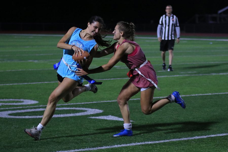 Rushing across the field, junior Jane McDaneld attempts to stop senior Quincy Hubert.