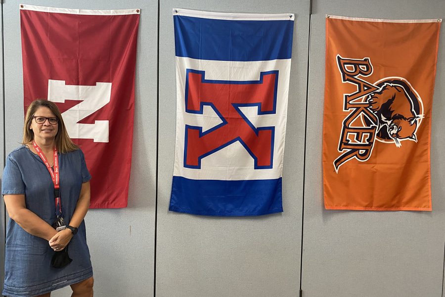 Standing beside the flags of three colleges she attended, math teacher Michele Anderson talks about her love for math and how her main goal is to help kids “understand the importance of math without it having to be frightening.”

