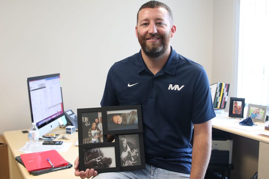 After moving here from Holton, Kansas to be closer to family, assistant principal and athletic director Brent Bechard holds a picture frame of his wife and child.