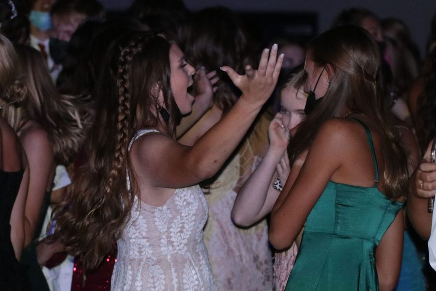 Throwing her hands up, sophomore Kate Pfeister sings along to the music.

