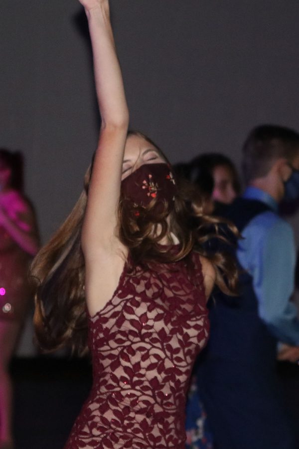 Near the end of the dance, senior Ella Tow throws her hands up in the air as she continues dancing.
