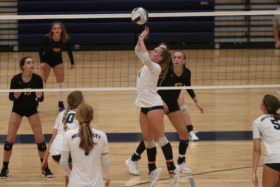 While her teammates prepare to hit, senior Sydney Fiatte sets the ball.
