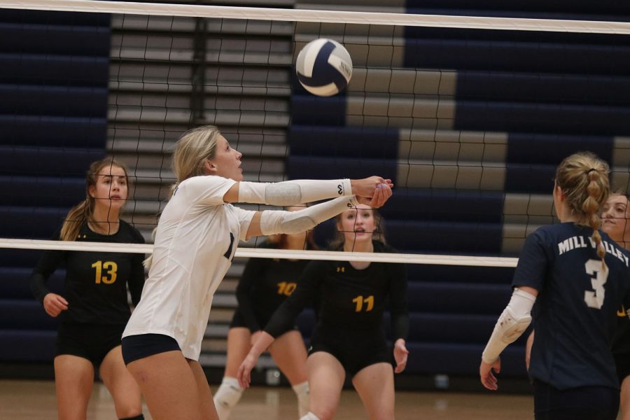 Next to the net, senior Kate Roth passes the ball.