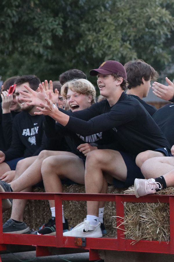 Attempting to catch candy being thrown at them, seniors Ben Fitterer and Aidan Jacobs laugh and reach out their hands. 
