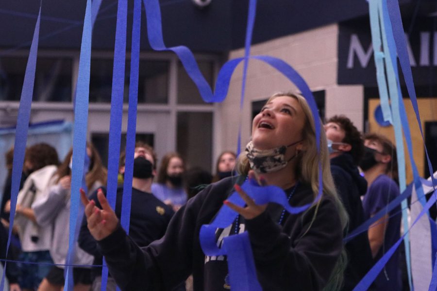 Looking up, senior Maggie Smith smiles as the streamers she threw rain down on her.