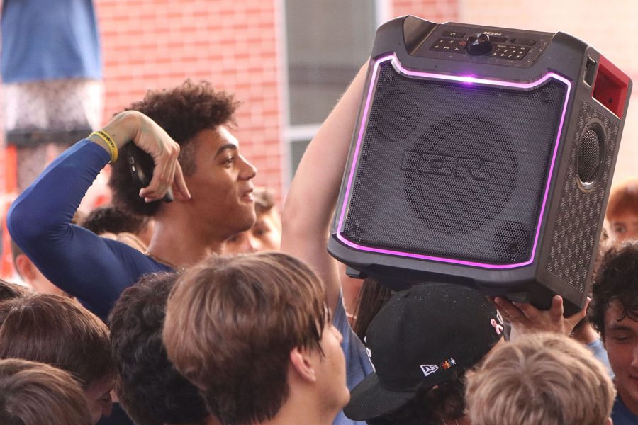 Jumping to the beat of the music, senior Adrian Dimond participates in the mosh pit as his classmate lifts the speaker above his head.