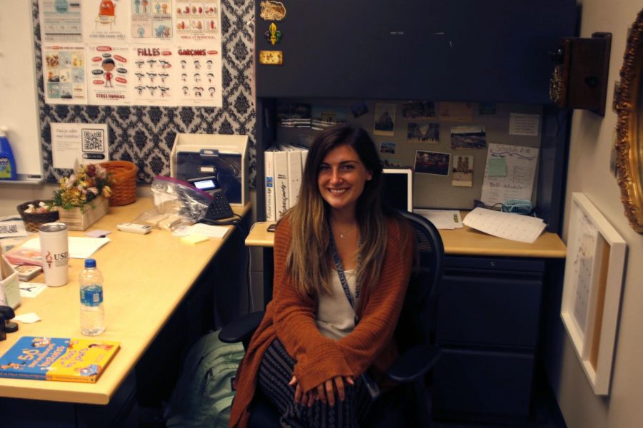 French teacher Michelle McRay sits at her desk in front of all her photographs that each hold their own significant meaning