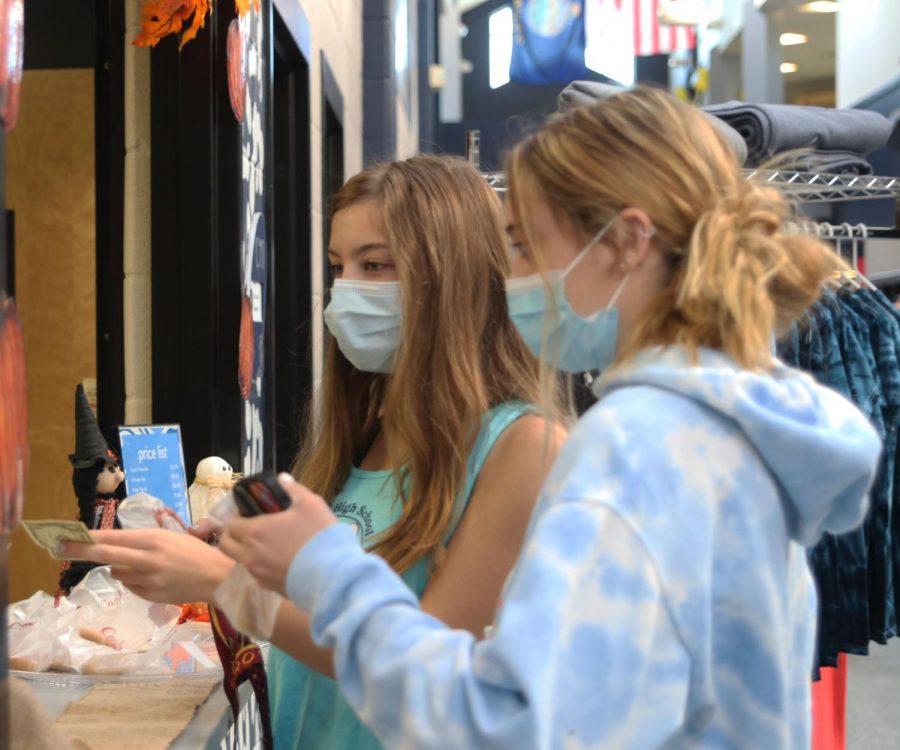 Handing the money over, seniors Aly Brown and Emma Bilhimer buy cookies. 
