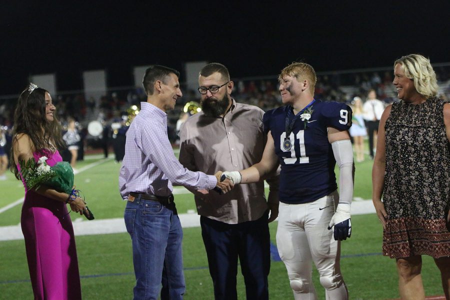 While meeting their partner, Homecoming queen candidate senior Quincy Hubert’s father shakes Homecoming king candidate senior Cody Moore’s hand.