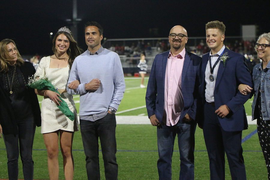After their names were announced, Homecoming queen candidate senior Logan Pfeister and Homecoming king candidate senior Declan Taylor stand next to their parents.