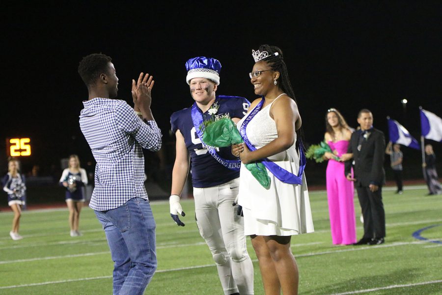 Previous Homecoming king Quinten Wittenauer applauds Homecoming king senior Cody Moore and Homecoming queen senior Hannah Hunter.