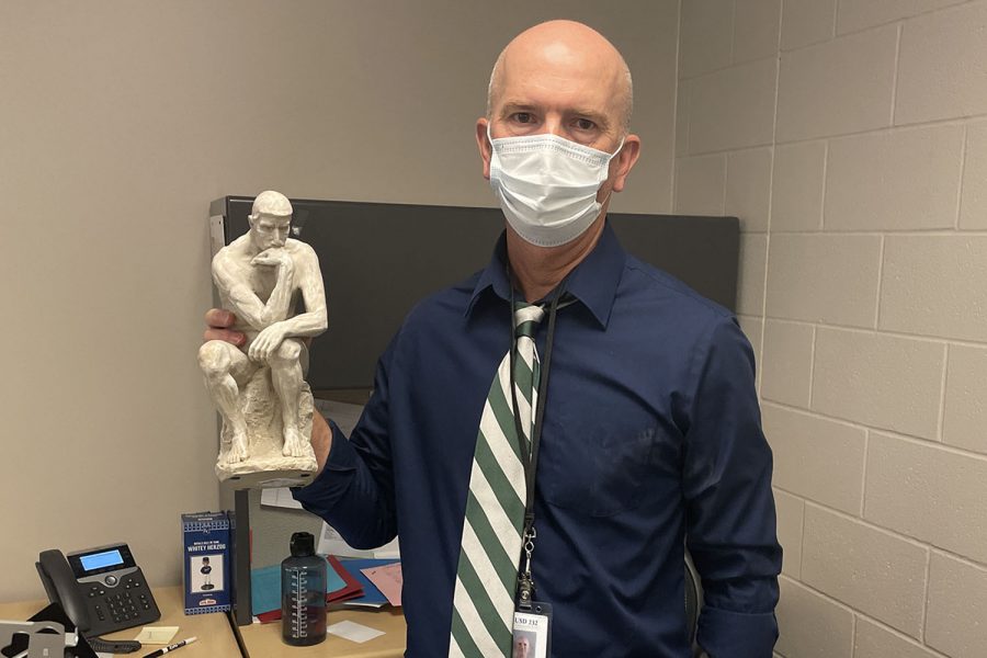 Soccer coach and social studies teacher Jason Pendleton holds a statue of “The Thinker” he has displayed in his classroom. Pendleton looks forward to “building positive relationships with kids”.
