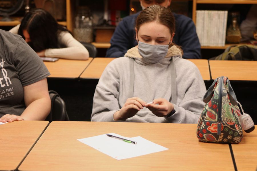 Folding over her piece of paper, senior Kayla Brethauer plays the question game with the class.