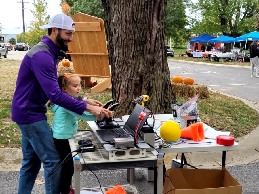Smiling, a father and daughter work together to manipulate one of the teams robots Saturday, Oct. 23