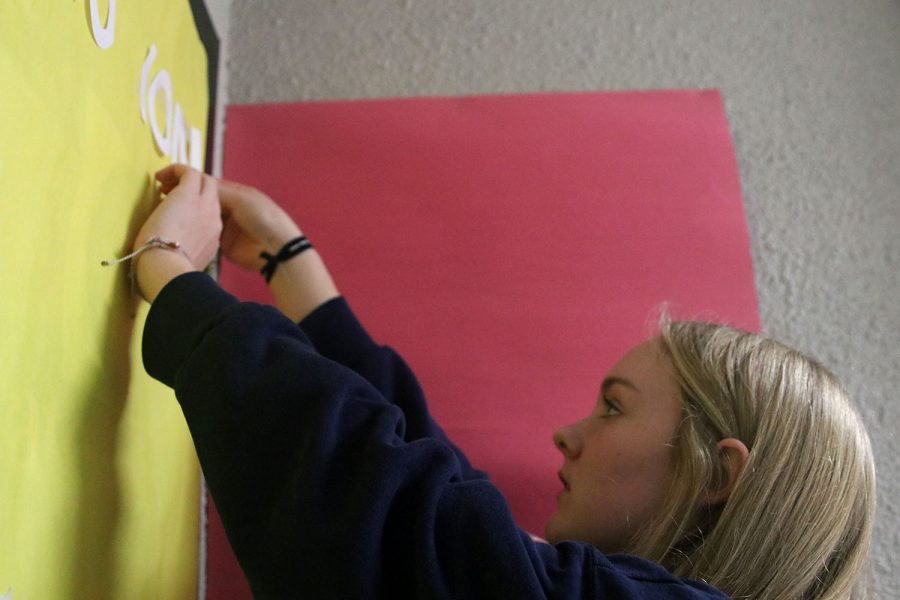Taping down a letter, sophomore Addison Bailey finishes the word “emotions” to bring awareness to mental health issues high school students face.