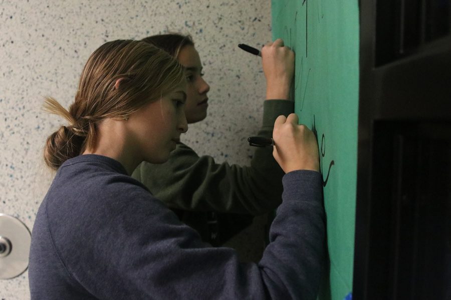 To participate in the jagPRIDE red ribbon week, freshman Maggie Wieland writes encouraging words on her seminar door.