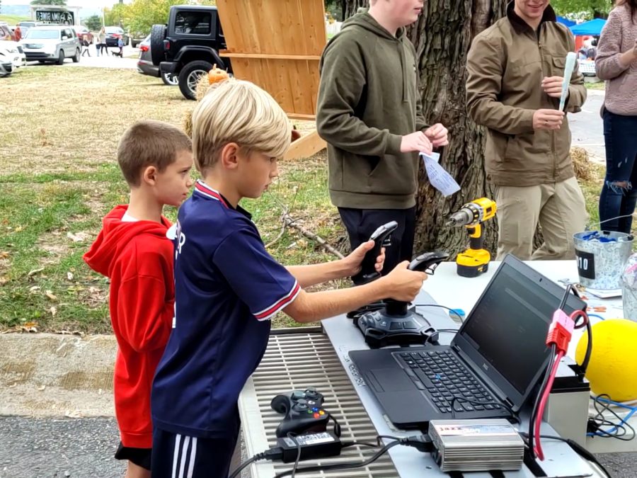 Carefully maneuvering the controllers, a boy at the Imagine Furever Ranch Fall Festival drives a robot Saturday, Oct. 23