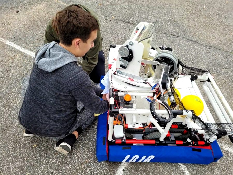 Juniors Isaac Steiner and Connor Bauer work together to replace a robots battery Saturday, Oct. 23