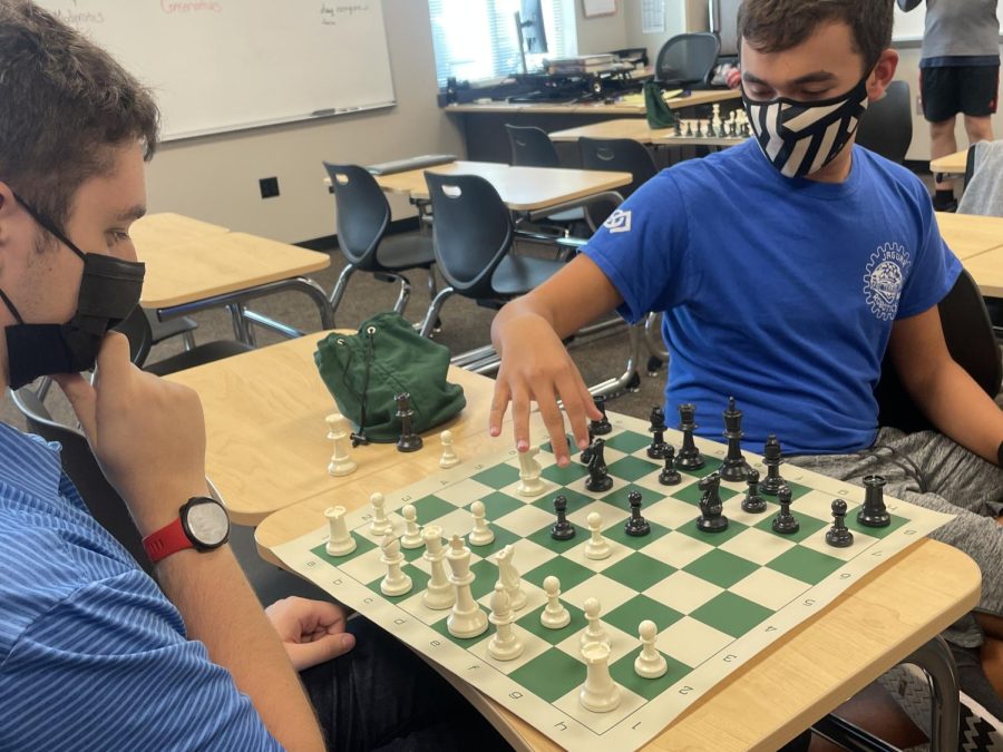 Junior Isaac Steiner makes his move while Senior Colin Keltner watches, thinking about his strategy 