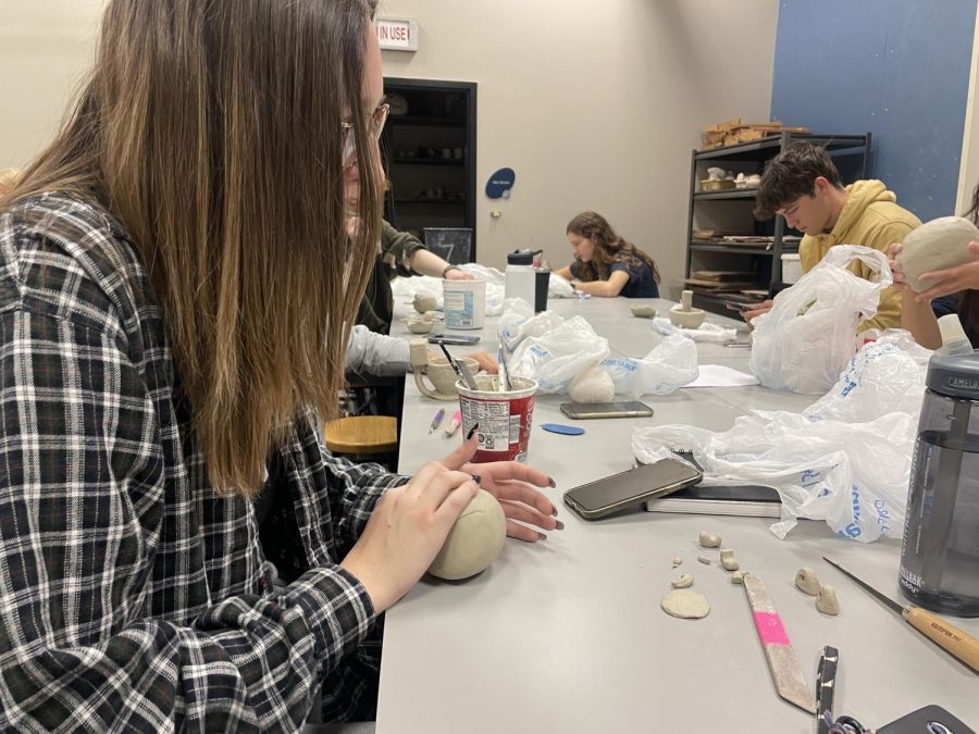 Senior Ashleigh Krist shapes the clay for her pinch form project. 