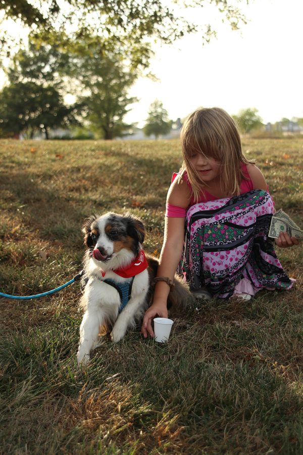 Pup cup in hand, third-grader Isla Davidson finishes feeding the cup to her friend's dog.
