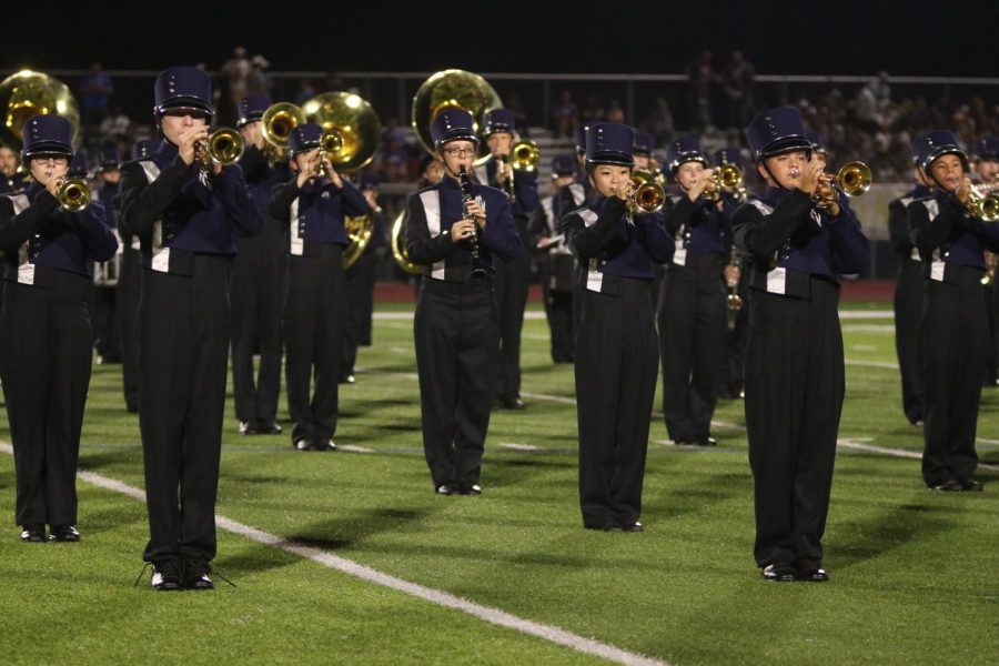 Standing at attention, the band angles their horns upward to play out on Friday, Oct. 8