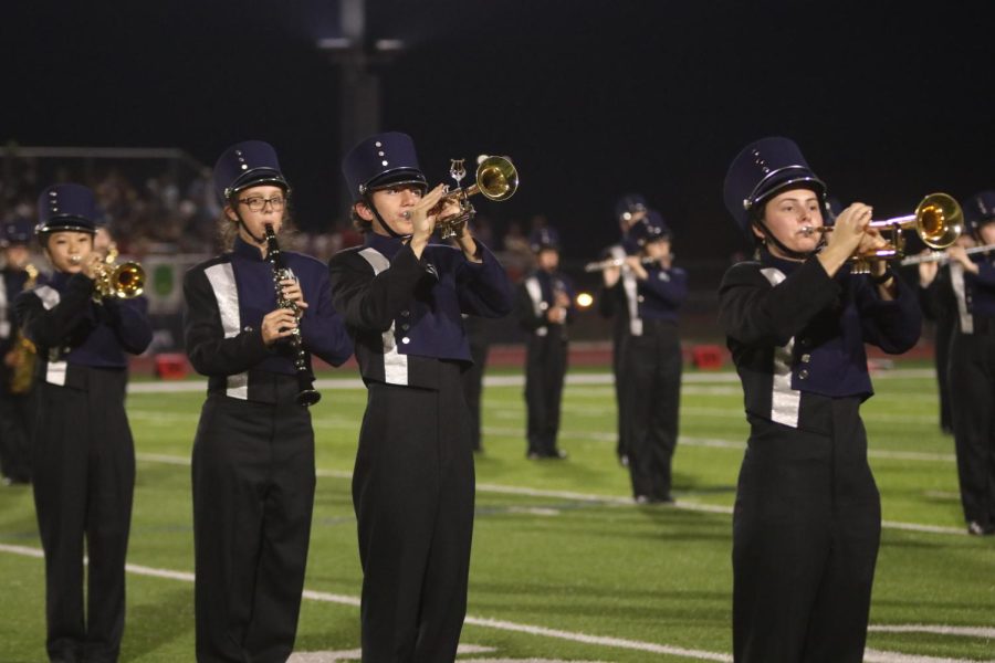 Senior Katelyn Kurovski and junior Charles Beal stand in line and play their trumpets