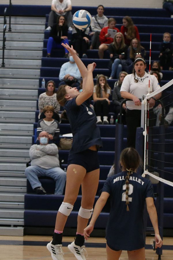 In the air, freshman Saida Jacobs hits the ball over the net.