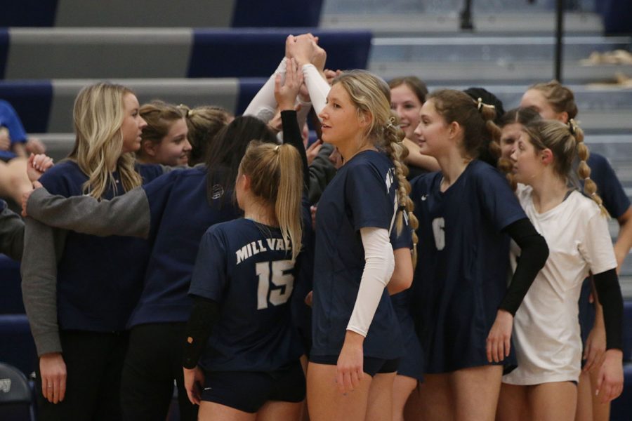 After a timeout, the team cheers together in a huddle.