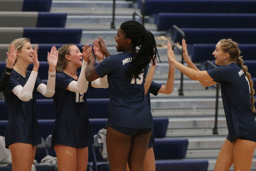 Preparing to go out on court, seniors Taylor Roberts and Reese Johnston high five their other teammates.