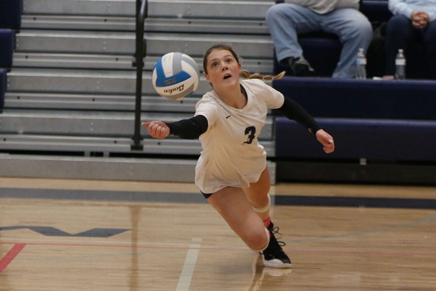 Diving toward the middle of the court, junior Sidney Kacsir attempts to save the ball.
