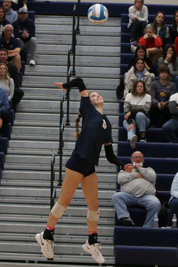 High in the air, sophomore Kaitlyn Burke reaches up to hit the ball.