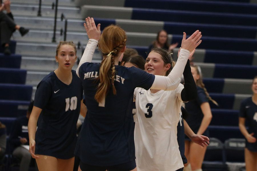 After scoring a point, senior Brylee Peterson high fives junior Sidney Kacsir.
