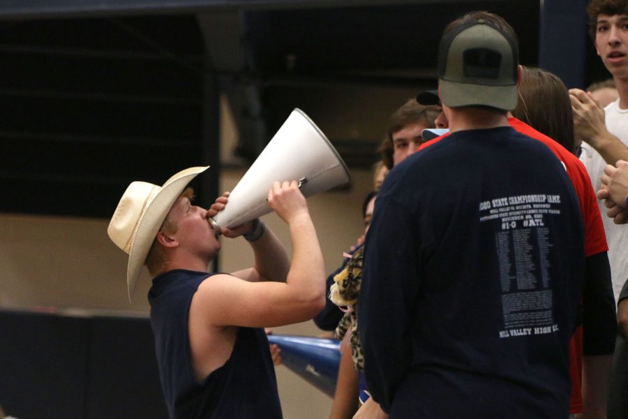 At the front of the student section, senior Cody Moore leads the crowd in a chant using a megaphone.