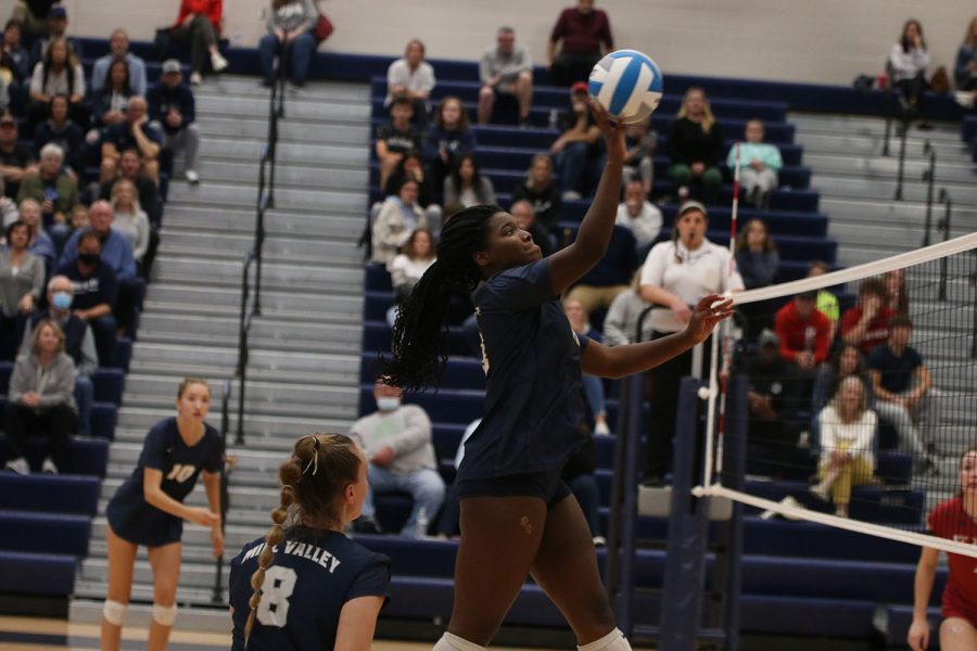 In the air, senior Taylor Roberts hits the ball.