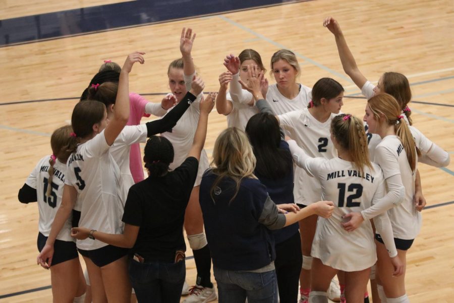 During the game, the volleyball team huddles to discuss what they will do next