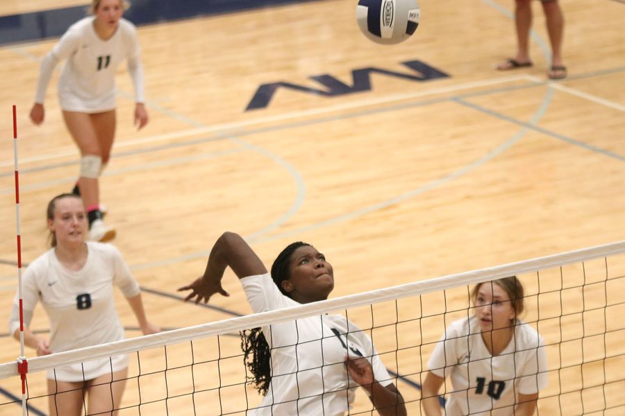 Senior Taylor Roberts jumps to spike the ball, securing a point for the team