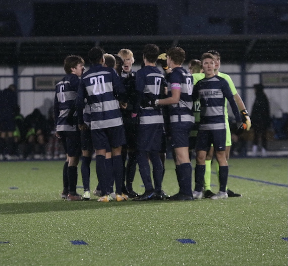 Before the regionals game, the boys soccer team gets together in a huddle.