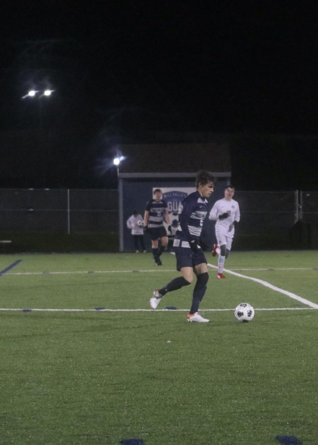 With the ball at his feet, senior Brooks Scheelk dribbles the ball past midfield.