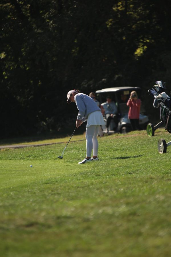 Looking at the ball, senior Libby Green hits it toward the hole.