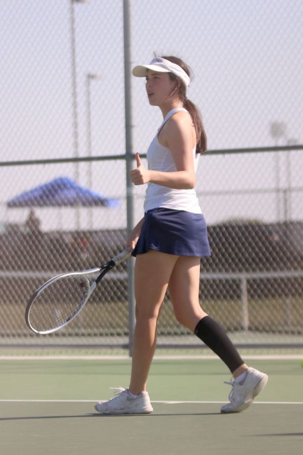 Motioning to her doubles partner, senior Eden Schanker congratulates senior Lauren Butler on her shot.