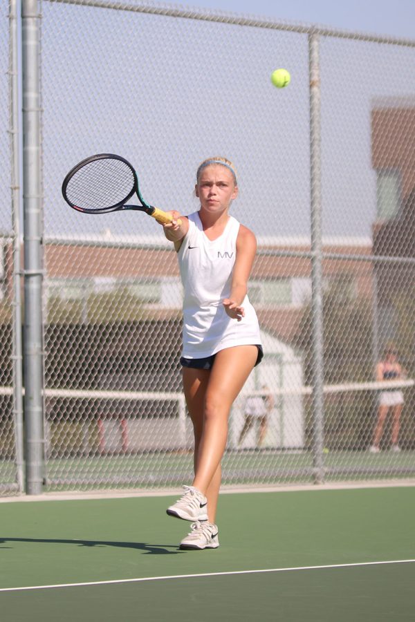 Returning the ball to her opponent, junior Bri Coup follows through with her shot.