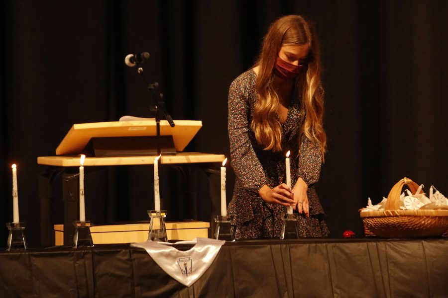 Senior Mackinley Fields lights a candle representing one of the NHS pillars.