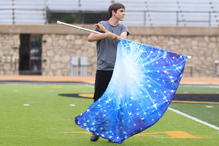 Spinning the flag, junior Garrett Cowen performs with the color guard.