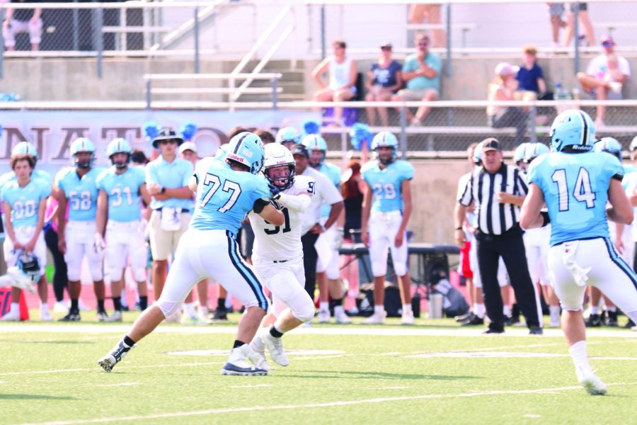 Going for the sack, senior defensive end Cody Moore fights his way through the Shawnee Mission East offensive line to take victory on Friday, Sept. 17.

